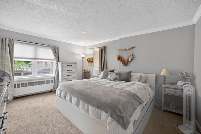 Bedroom with radiator heating unit, crown molding, a textured ceiling, and carpet | Image 17
