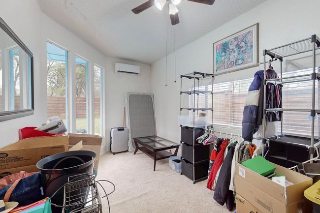 Bedroom featuring multiple windows, a wall mounted AC, carpet floors, and a ceiling fan | Image 29