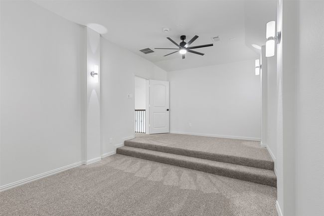 Carpeted empty room featuring visible vents, a ceiling fan, and baseboards | Image 27