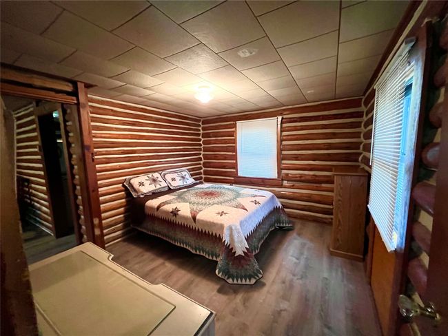 Bedroom featuring log walls and wood finished floors | Image 6