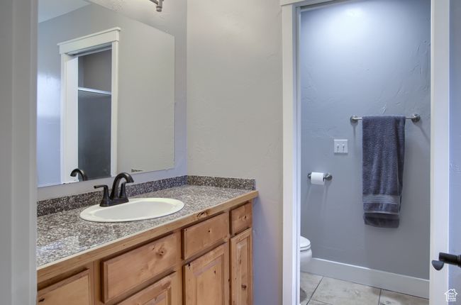 Bathroom with baseboards, tile patterned flooring, vanity, and toilet | Image 28