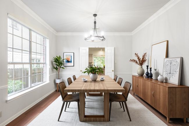 Dining room with crown molding, light wood finished floors, baseboards, and a chandelier | Image 7