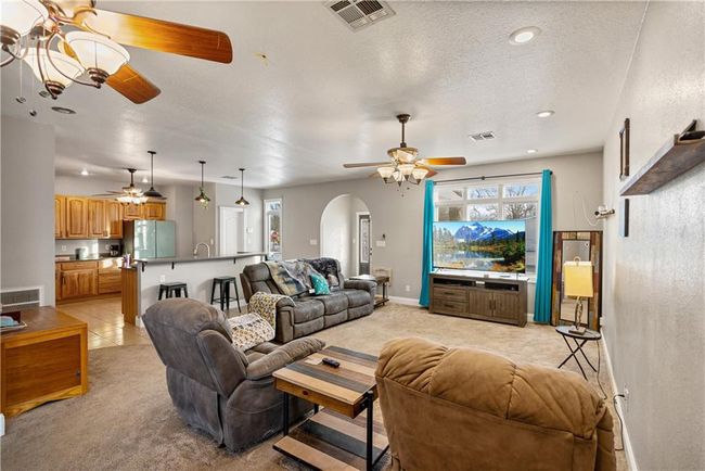 Carpeted living room with a textured ceiling and ceiling fan | Image 19
