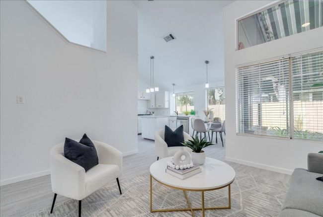 Living area with a high ceiling, light wood-type flooring, and baseboards | Image 14