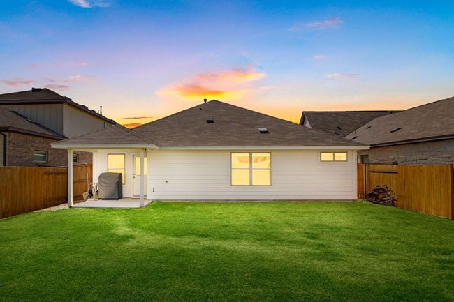 Back of property at dusk featuring a shingled roof, a fenced backyard, and a patio | Image 31