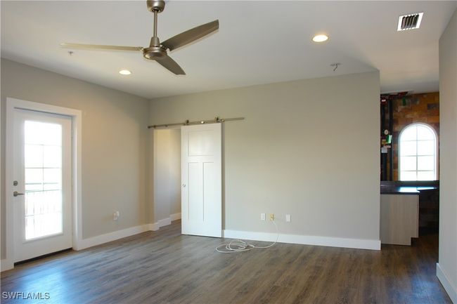 Spare room with a barn door, dark wood finished floors, ceiling fan, and recessed lighting | Image 9