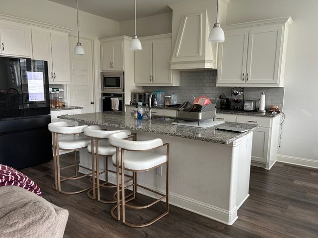 Kitchen with baseboards, dark wood-style floors, white cabinetry, tasteful backsplash, and appliances with stainless steel finishes | Image 7