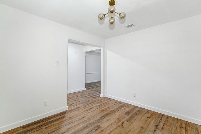 Unfurnished room with baseboards, a chandelier, and light wood-style flooring | Image 7