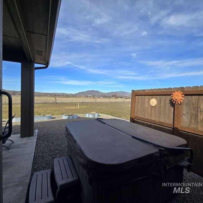 View of yard featuring a hot tub, a mountain view, and a patio | Image 24