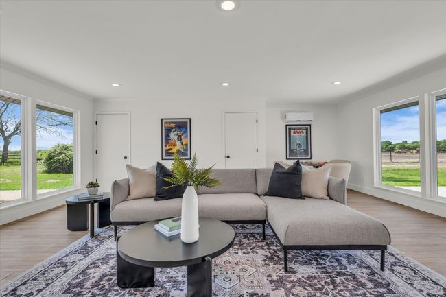 Living room with light wood-style flooring, crown molding, and a wealth of natural light | Image 26