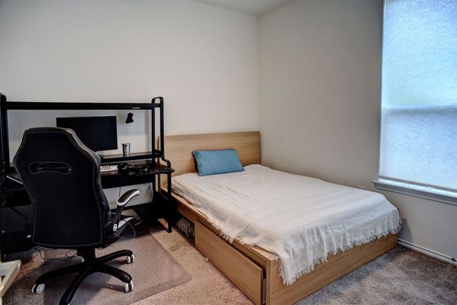Bedroom with carpet and an office area | Image 27