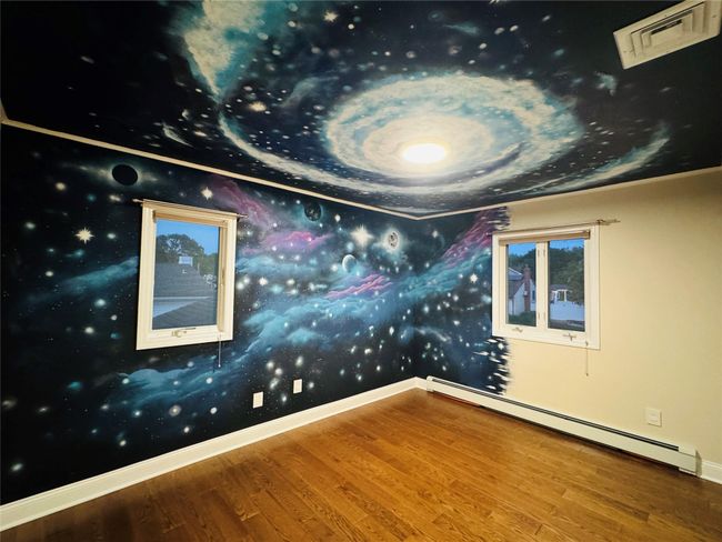 Bedroom featuring baseboard heating, wood finished floors, and wallpapered walls | Image 10