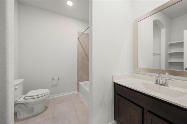 Secondary bathroom featuring toilet, vanity, tile patterned flooring, baseboards, and tub / shower combination | Image 30