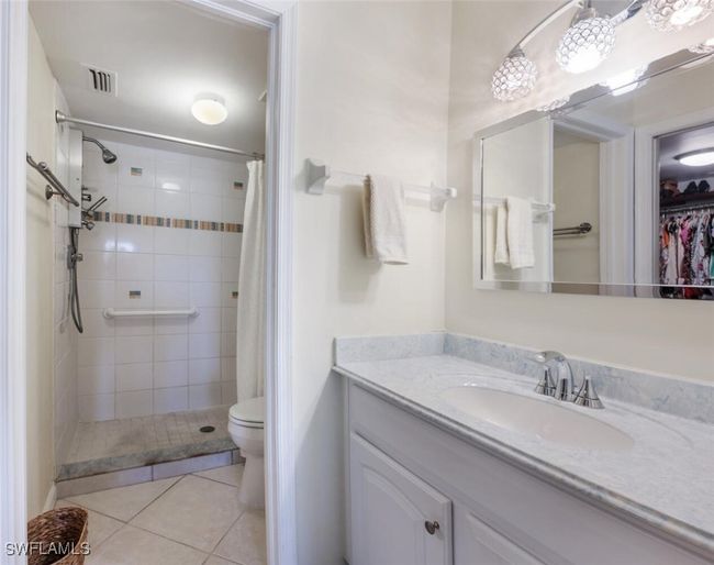 Full bath with tile patterned floors, a tile shower, toilet, vanity, and visible vents | Image 11