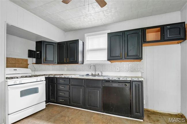 Kitchen with white range with gas cooktop, dishwasher, decorative backsplash, and a ceiling fan | Image 10