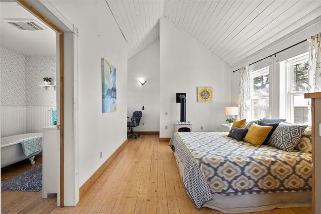 Bedroom with wainscoting, wallpapered walls and light wood-type flooring | Image 14