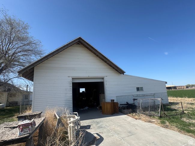 View of home's exterior featuring concrete driveway, an outdoor structure, fence, and a garage | Image 15