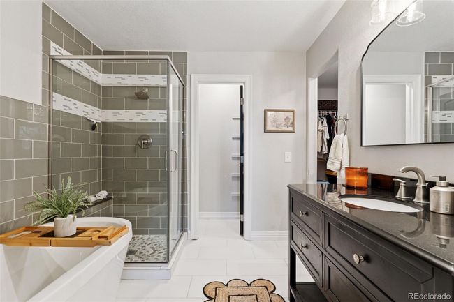 the primary bath is been beautifully updated with new tile, soaking tub, seperate shower and vanity. You'll love the adjacent walk-in closet! | Image 20