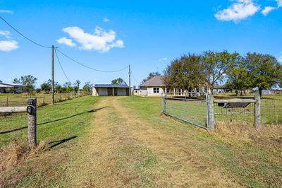 Welcome to your private retreat, featuring a charming entrance gate that opens to a serene countryside setting, inviting you into a spacious property with a picturesque rural backdrop. | Image 3