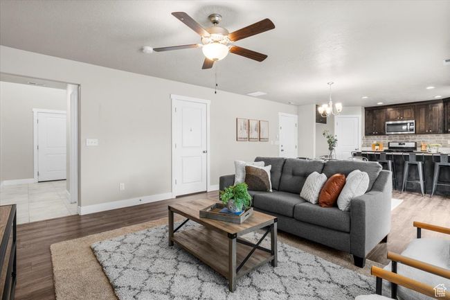 Living room featuring a chandelier, ceiling fan, baseboards, light wood finished floors, and recessed lighting | Image 11