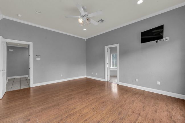 Unfurnished room featuring crown molding, ceiling fan, wood finished floors, and recessed lighting | Image 22