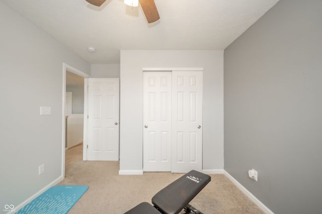 workout room with light carpet, a ceiling fan, and baseboards | Image 26