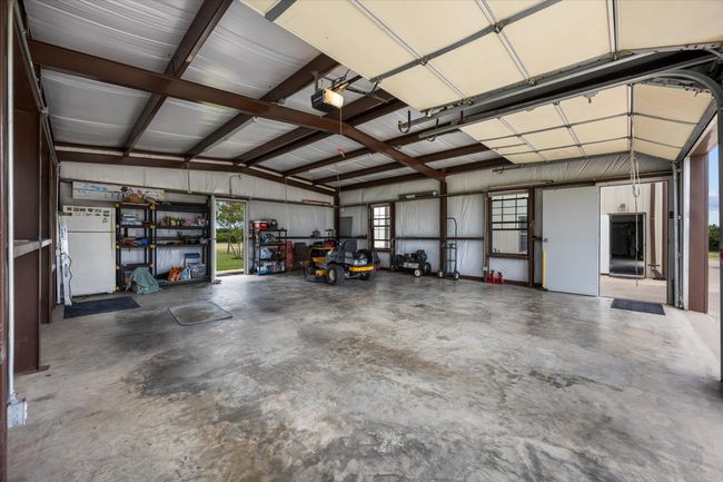 Garage with a garage door opener and freestanding refrigerator | Image 9