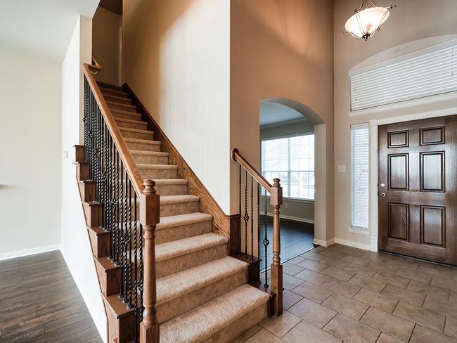 Tiled foyer with arched walkways, a high ceiling, stairs, and baseboards | Image 7