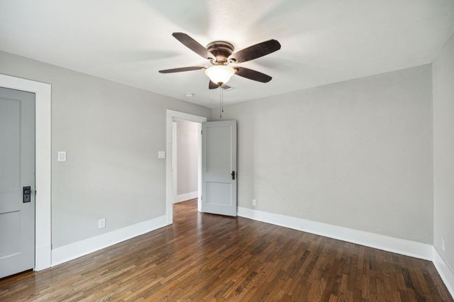 Unfurnished bedroom with dark wood finished floors and ceiling fan | Image 12