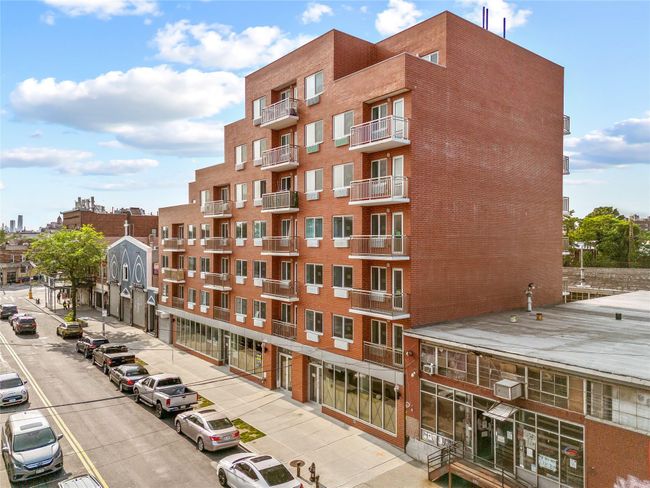 View of apartment building / complex with uncovered parking | Image 4