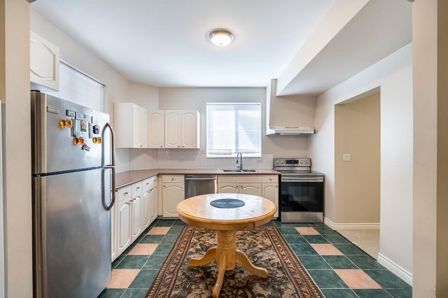 Kitchen featuring under cabinet range hood, baseboards, decorative backsplash, a sink, and appliances with stainless steel finishes | Image 33