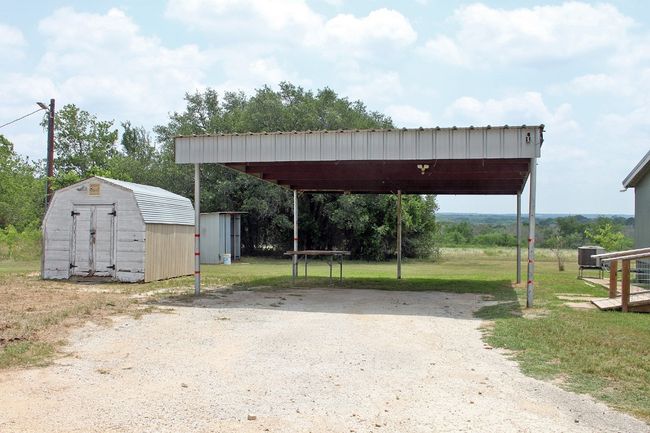 View of parking with a storage shed and a detached carport | Image 14