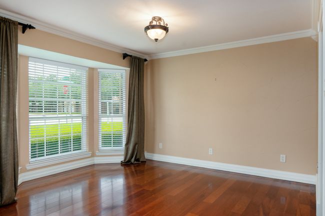Spare room featuring healthy amount of natural light, ornamental molding, and dark wood-type flooring | Image 9