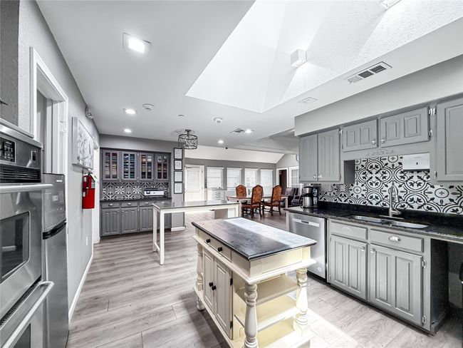 Kitchen with backsplash, gray cabinets, light wood finished floors, appliances with stainless steel finishes, and recessed lighting | Image 14