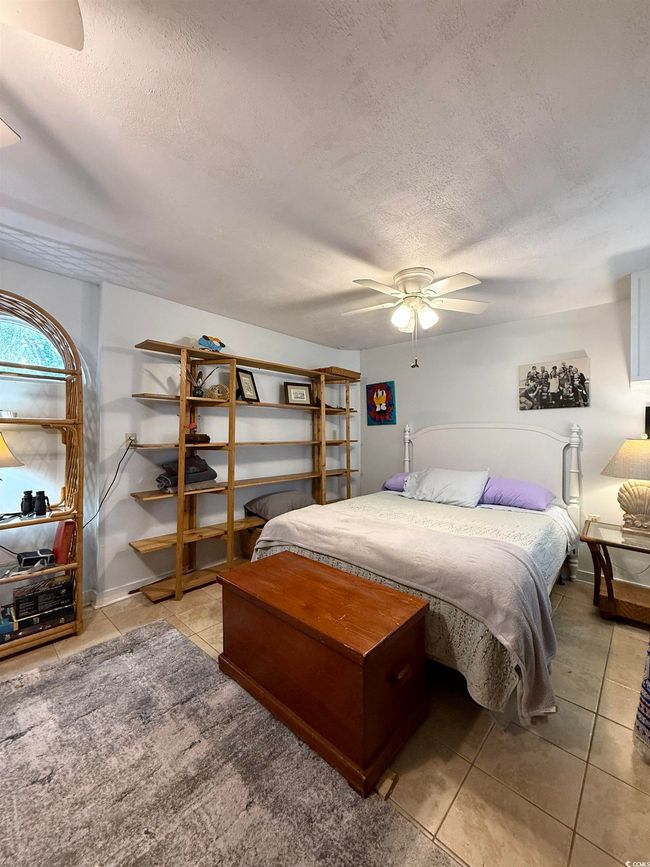 Bedroom with a ceiling fan, a textured ceiling, and tile patterned flooring | Image 23