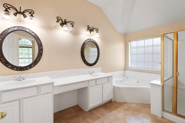 Bathroom featuring vaulted ceiling, a bath, double vanity, and a shower stall | Image 15