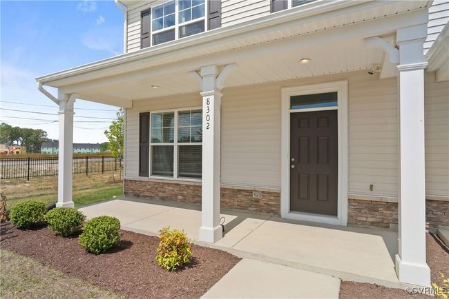 View of exterior entry featuring fence, a porch, and stone siding | Image 4