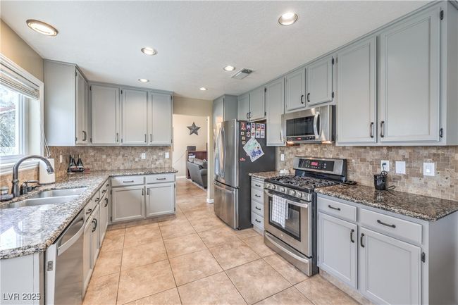 Kitchen featuring, a sink, stone countertops, appliances with stainless steel finishes, and light tile patterned flooring | Image 19