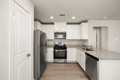 Stainless Steel appliances with white cabinets. | Image 3