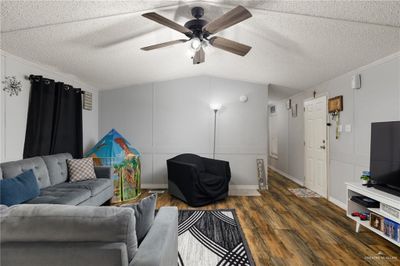 Opposite view of the living room facing the side entrance and hallway to bedrooms. | Image 3