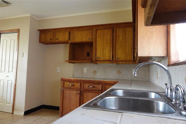 Charming kitchen with ample cabinet space, a dual sink, and natural light perfect for any home chef. | Image 30