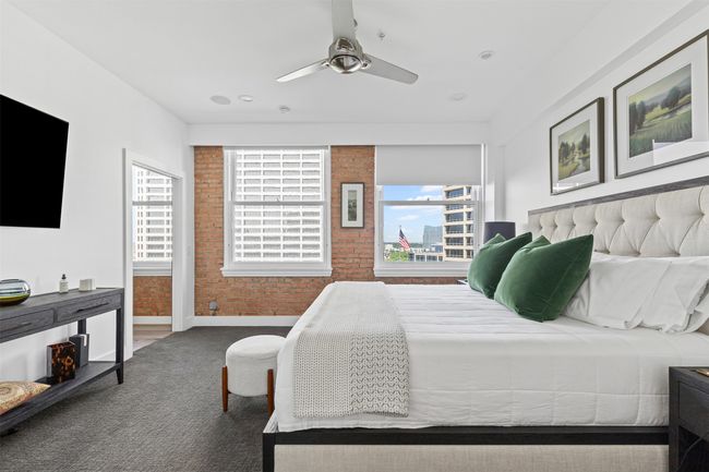 Carpeted bedroom with brick wall, baseboards, and a ceiling fan | Image 18