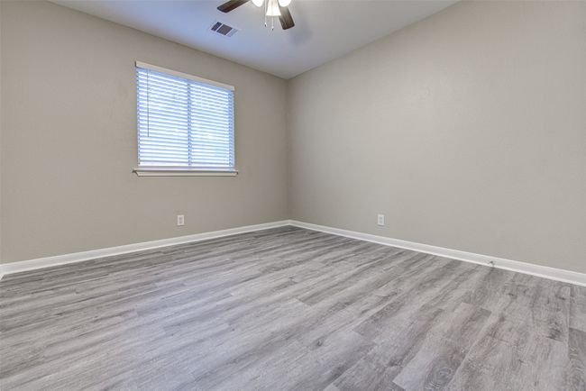Empty room featuring a ceiling fan and wood finished floors | Image 18