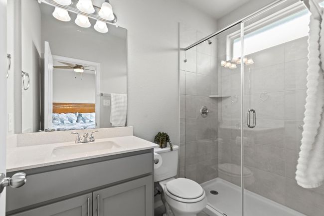 Ensuite bathroom with vanity, toilet, a stall shower, and a ceiling fan | Image 10