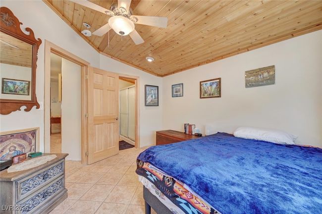Bedroom featuring wood ceiling, light tile patterned floors, lofted ceiling, and ceiling fan | Image 50