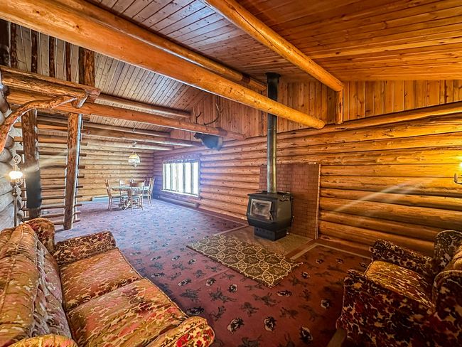 Unfurnished living room featuring a wood stove, vaulted ceiling with beams, wood ceiling, and carpet flooring | Image 29