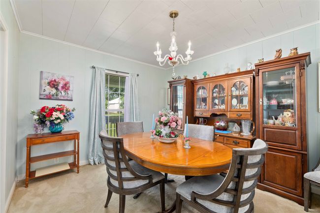 Soft, sage green painted walls and accent lighting in the formal dining area. | Image 13