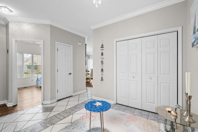 Unfurnished bedroom featuring light tile patterned flooring, multiple windows, ornamental molding, and baseboards | Image 6