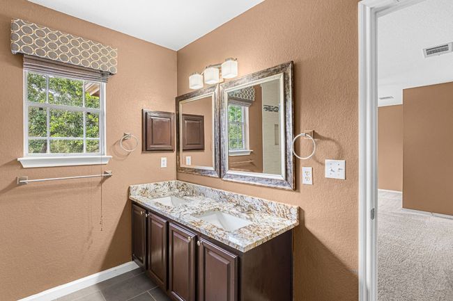 Full bath featuring healthy amount of natural light, double vanity, a textured wall, and tile patterned​​‌​​​​‌​​‌‌​‌‌​​​‌‌​​‌‌​‌​​​​​‌ floors | Image 24