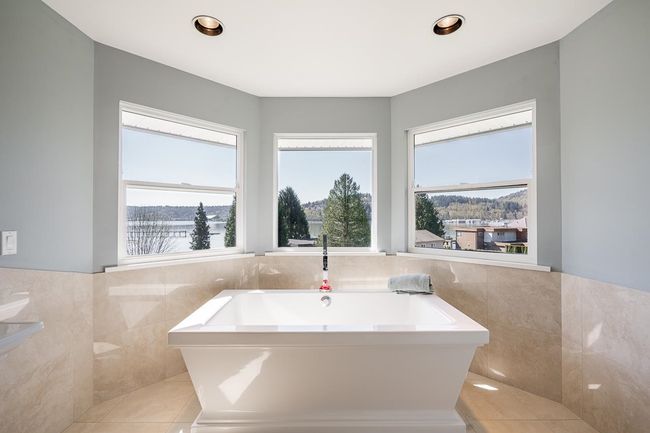 Full bathroom featuring a bathtub, tile walls, plenty of natural light, tile patterned flooring, and a wainscoted wall | Image 20